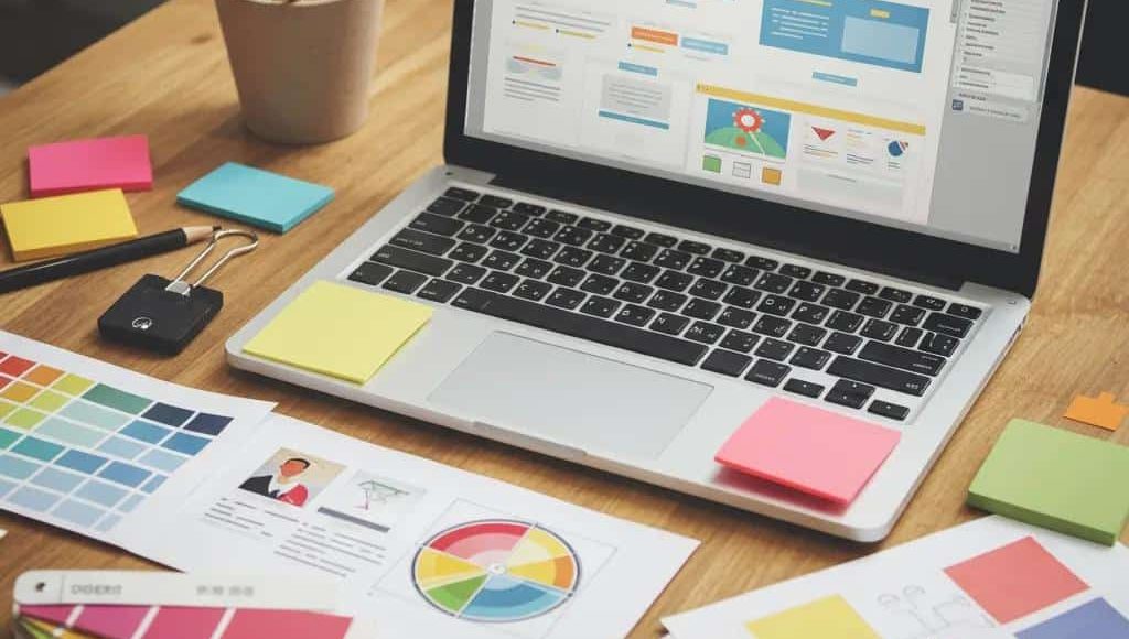 Modern web design workspace with a laptop displaying a creative website, emphasizing functionality and human-centered design