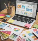 Modern web design workspace with a laptop displaying a creative website, emphasizing functionality and human-centered design